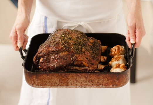 Chef Holding a Pan with Prime Rib Roast with Garlic