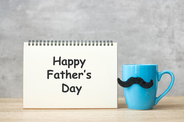 Happy Father day with paper notepad, Blue coffee cup or tea mug and Black mustache decor on table. International men day and celebration concept
