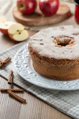Sponge cake or chiffon cake with apples so soft and delicious sliced ​​with ingredients: cinnamon, eggs, flour, apples on wooden table. Home bakery concept for background and wallpaper