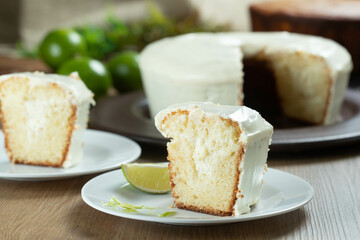 Close up piece of Moist lemon fruit cake on plate with lemon slices on wooden table. Delicious breakfast, traditional tea time. Lemon cake recipe.