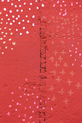 rough stucco wall painted in red with yellow dots design. urban grunge background.