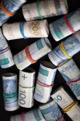 Many rolls of paper bills. Various denominations of Polish national currency.