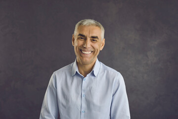 Headshot portrait of smiling middle-aged Caucasian man on black studio background laugh joke. Profile picture of happy overjoyed mature male have fun feel excited talk speak on video call. Diversity.