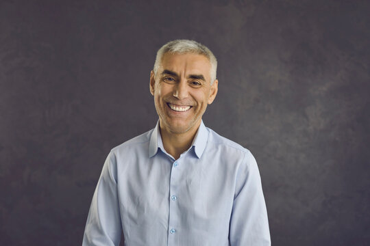 Headshot portrait of smiling middle-aged Caucasian man on black studio background laugh joke. Profile picture of happy overjoyed mature male have fun feel excited talk speak on video call. Diversity.
