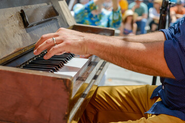 Closeup of unidentified musician's hands playing piano at outdoor free festival (French Quarter Festival) in New Orleans, LA, USA - Powered by Adobe