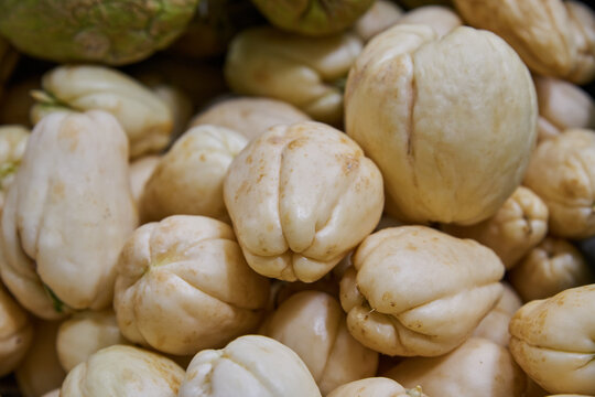 Yellow chayotes put on a shelf for sale in a market