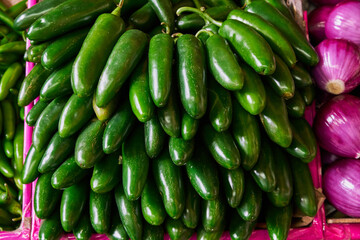 Jalapeño peppers placed on a shelf for sale inside a market