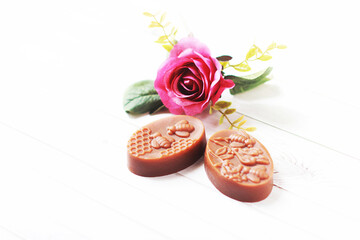 Rose Handmade Soap Take a photo with blooming roses On a white wooden floor., herbal soap., close-up photo.