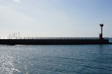 lighthouse and distant turbine