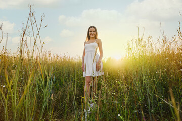 Beautiful young woman walking in the field