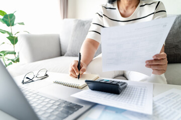 Woman is calculating annual tax with calculator and filling form of Individual Income Tax Return. Season to pay Tax and Budget planning concept. - obrazy, fototapety, plakaty