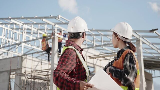Two architect and client discussing help create plan with blueprint home building at construction site