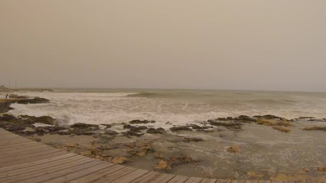 Gopro video of waves crashing against the rocks and heavy winds in Torrevieja, a tourist town at Costa Blanca Spain during a calima which is sand or dust suspended in the air