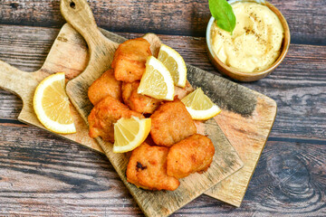   Allasca Pollock Fish  Bites in a crispy Tempura  Batter.Fish and chips .Close up of   crispy breaded  deep fried fish fingers with breadcrumbs s erved with remoulade sauce and  lemon