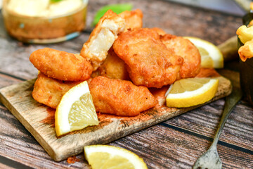   Allasca Pollock Fish  Bites in a crispy Tempura  Batter.Fish and chips .Close up of   crispy breaded  deep fried fish fingers with breadcrumbs s erved with remoulade sauce and  lemon