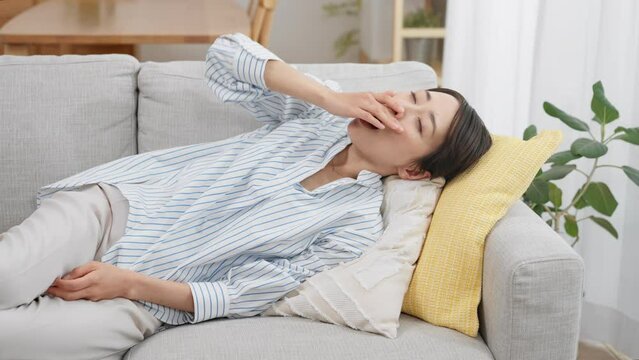 ソファーで昼寝をする若い女性