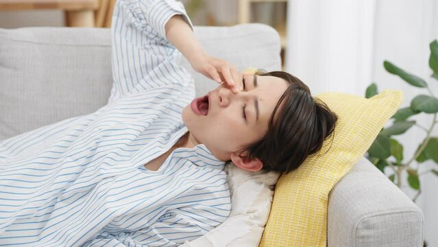 ソファーで昼寝をする若い女性