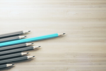 Obraz premium Concept of creativity, innovation, idea, crisis management and solution. One blue pencil standing out of line with similar ones, clean mock up space on wooden background. 3D Rendering.