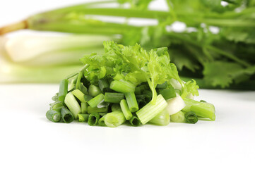 Fresh green coriander and spring onions cut into small pieces. Put together on a white background . It is a fragrant edible herb. Can be used for cooking and decorating food, can be eaten raw