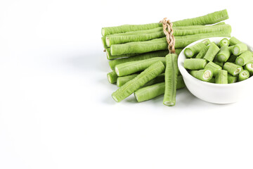 Long beans on a white background Cut into small pieces, put in a cup. close-up photo of green vegetables It's a kind of nut. You can eat it raw as a side dish.