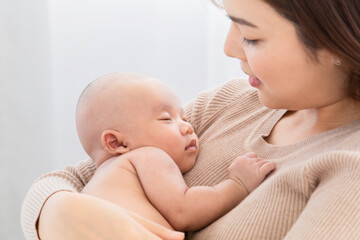 Selective focus Beautiful Asian mother holding newborn baby sleep on her lap, Young mom supports...