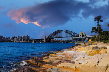 Naklejka premium Sydney Harbour Australia with nice colours in the sky. Nice blue water of the Harbour, high rise offices and residential buildings of the City in the background, NSW Australia