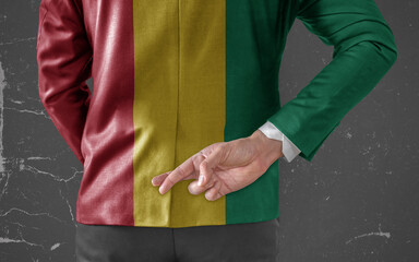Businessman Jacket with Flag of Guinea with his fingers crossed behind his back