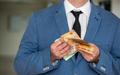 Businessman hiding euro bills in a suit pocket