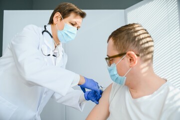 Female doctor vaccinating a man