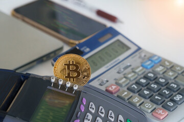 Bitcoin btc crypto currency as decentralized finance payment on credit card machine, calculator, mobile phone. Concept of contactless payment