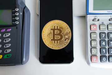 Bitcoin btc crypto currency as decentralized finance payment on credit card machine, calculator, mobile phone. Concept of contactless payment