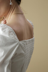 Fashion model wearing white peasant blouse, close up, studio shot.