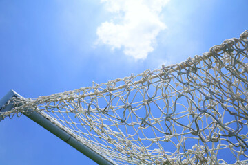A white soccer goal net on a sunny day.