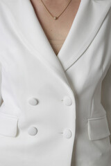 Close up image of white double breasted tailored blazer.