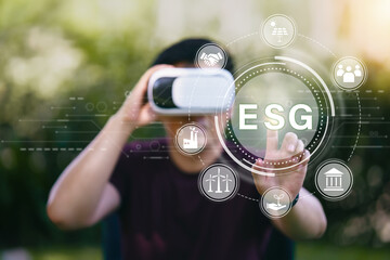 Young man using VR virtual reality headset with ESG icon concept for environmental, social, and...