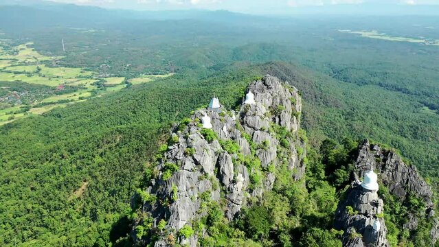 Panoramic view in orbit mode with drone from the top of a mountain in northern thailand surrounded by pagodas on each peak