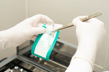 Manicure master hand lay out sterilizing manicure tools from craft package. concept of beauty....