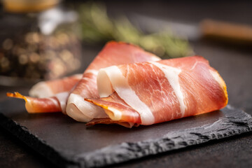 Sliced schwarzwald ham. Dried prosciutto ham on cutting board. - obrazy, fototapety, plakaty