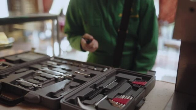 Master fixing coffee machine and shows thumb up sign. Woman uses tools for coffee maker repair. Quick fix service concept.