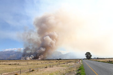 Fototapeta na wymiar Smoke billowing from a grassland fire on a farm near Worcester, Western Cape, South Africa.