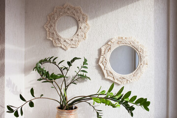 Macrame mirror and wreath on a white wall.  Eco-style. Natural materials.
