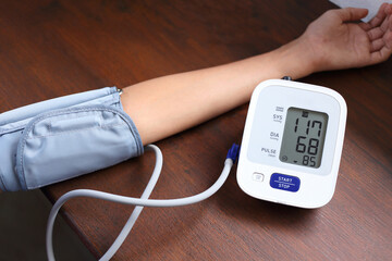 Kid normal blood pressure, Hand wear blood pressure arm cuff on wooden desk