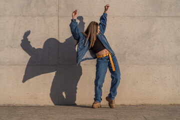 Young woman standing making movements with her body with her arms raised outside