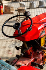 Partial close-up of a brand new red tractor in the countryside