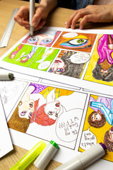 The artist designer draws sketches of comic book characters on paper. The animator creates a...