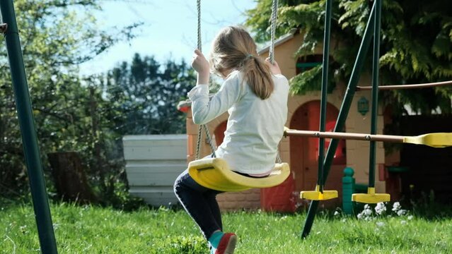 Fillette sur une balan&ccedil;oire au printemps sur fond de verdure - Slow motion - 120fps - ralenti