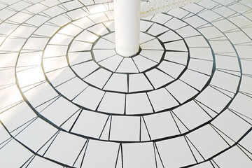White tiles in circle pattern with pole at the center for spiral staircase