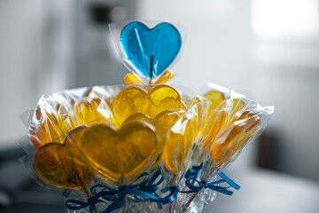 Yellow and blue heart shaped lollipops with caramel.
