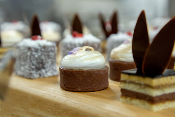 Lamington square cake Australian with coconut on a wooden board with sprinkles with grain and out of focus