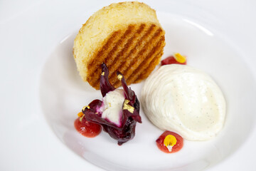 white plate with styled sweet sponge cake fig and ice cream gold leaves and flowers out of focus with grain